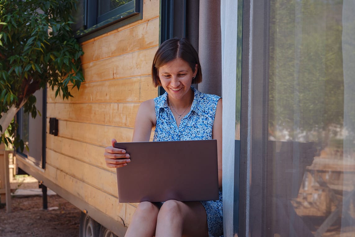 Woman uses laptop with internet in rural area.