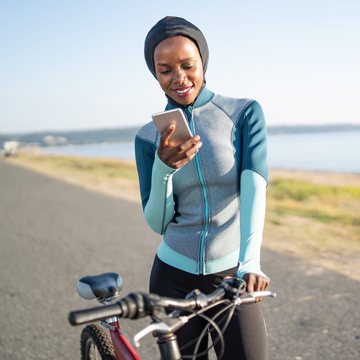 Woman using cell phone on bike ride